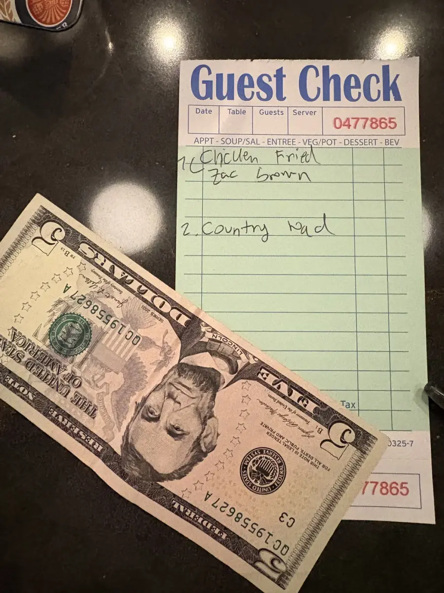 アヤ・ゴルフ・ラウンジのカラオケ会計伝票。1曲$2の料金 — Chicken FriedとCountry Roadsが記載されている