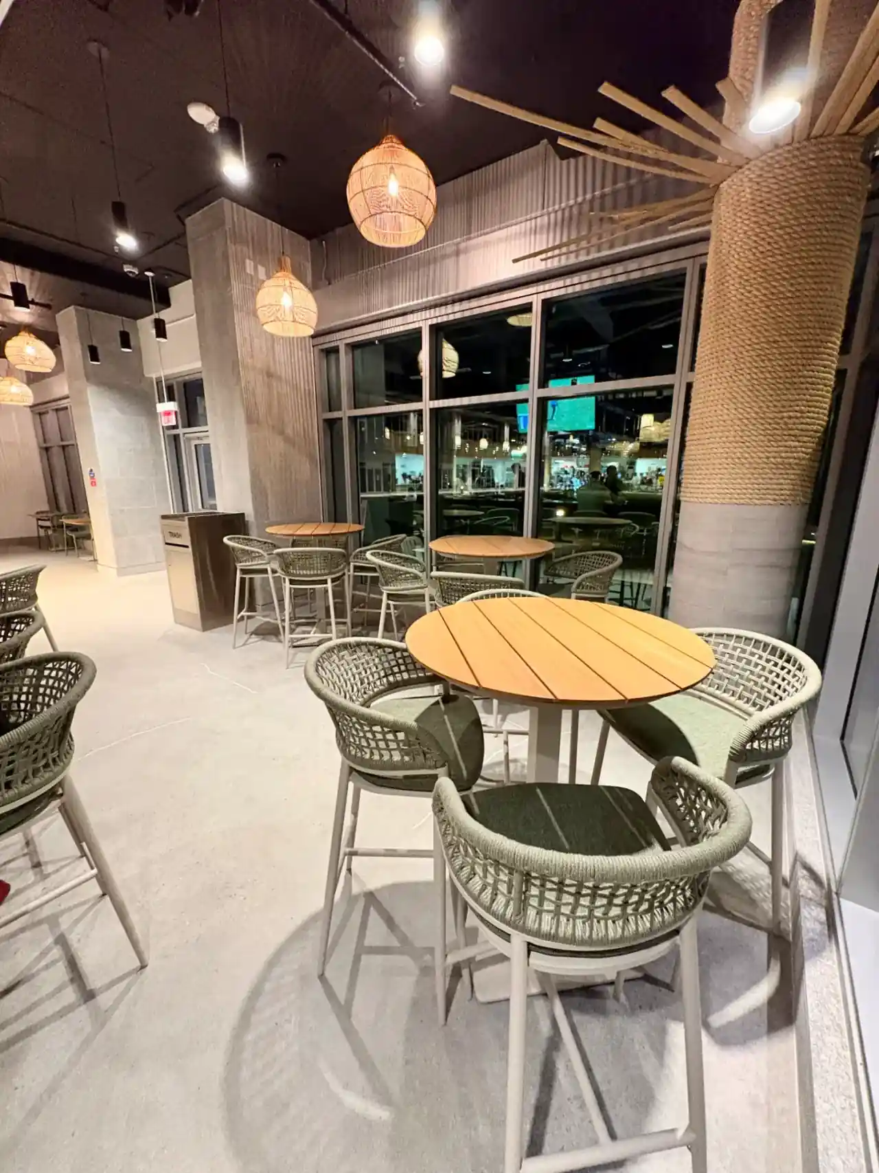 K Park Bar lounge area with woven rattan chairs tropical pendant lights and rope-wrapped column decor