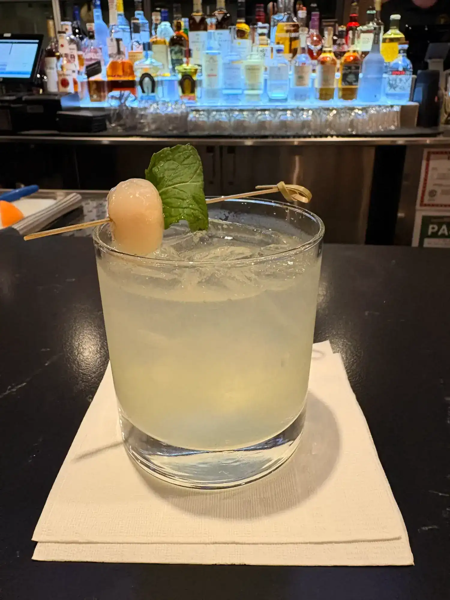 Refreshing lychee basil cocktail at K Park Bar garnished with fresh basil leaf and lychee fruit