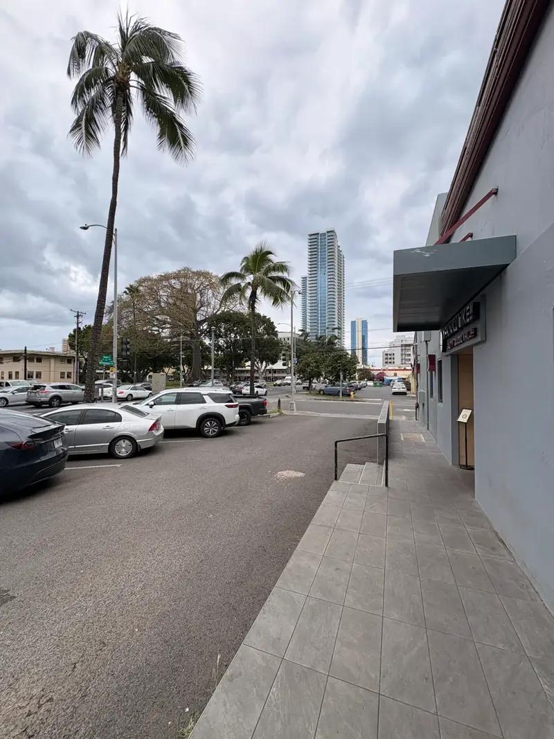 Free parking lot in front of Yakiniku Like Hawaii on Ke'eaumoku Street with palm trees and Honolulu skyline